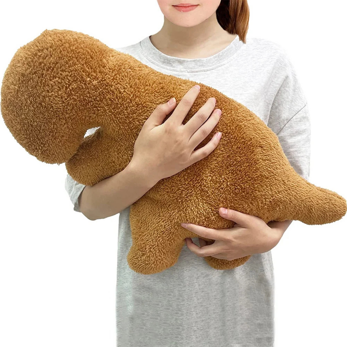 Person hugging a large Brontosaurus dinosaur nugget plush pillow to show its size