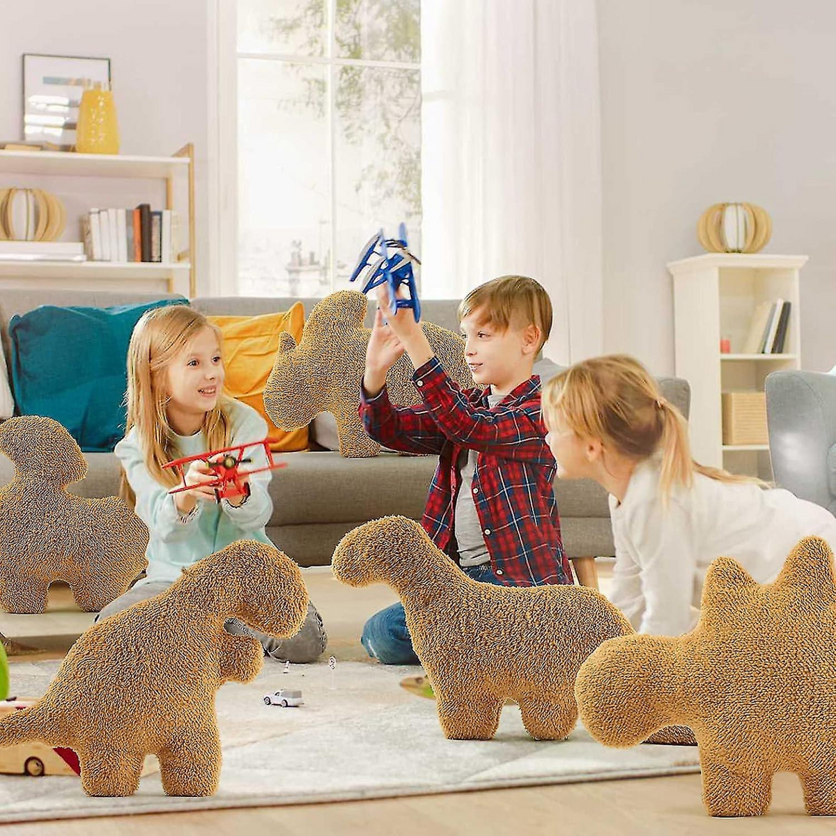 Children playing in a living room surrounded by large dinosaur chicken nugget plush pillows